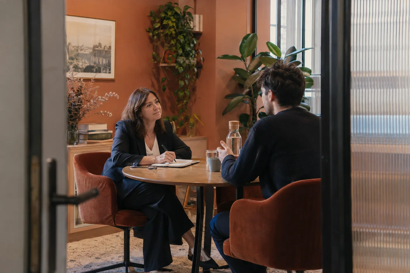 Une consultante et un candidat échangent dans un espace de recrutement chaleureux